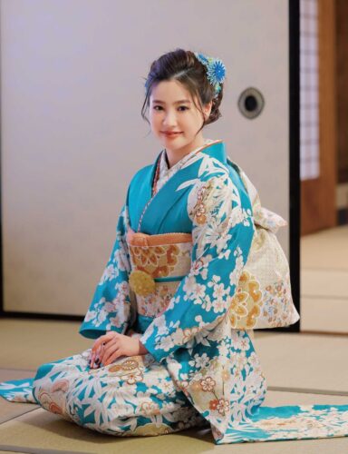 澄み渡った青空のようなターコイズと白の色合わせが秀逸。雪輪の中に咲く吉祥の花が寿ぎを告げ、手描き友禅ならではの品格が宿ります。