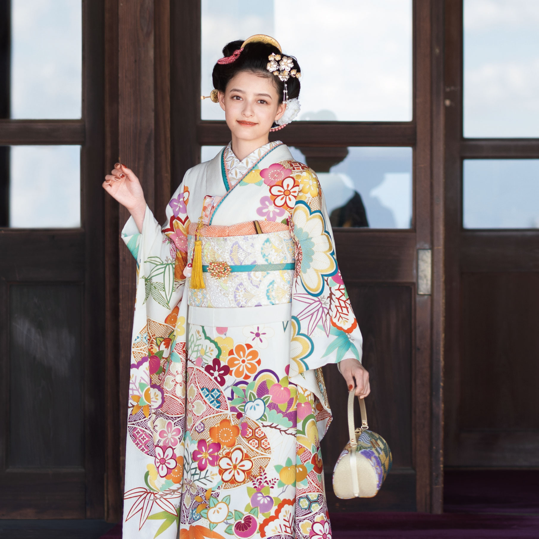 品の良さを醸し出す胡粉色の晴れ着は、華やかな色調の吉祥文様が好印象。表情豊かなちりめんの生地に、手描き友禅ならではの風雅が宿ります。
