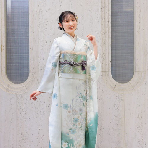 白と緑のグラデーションに菊模様が描かれた振袖を着た女性