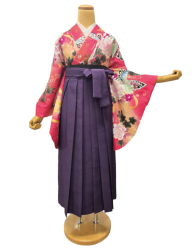 ピンク地に大輪の花と蝶が描かれた振袖に、深みのある色の袴を合わせた華やかな卒業式スタイル。