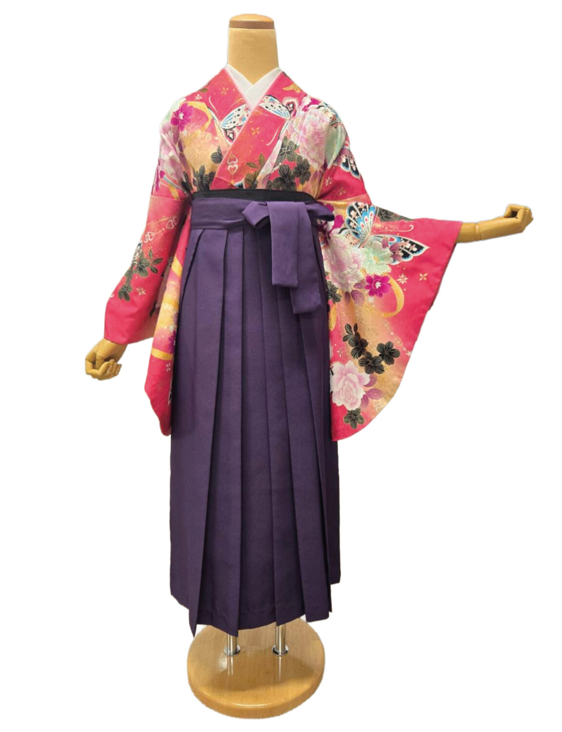 ピンク地に大輪の花と蝶が描かれた振袖に、深みのある色の袴を合わせた華やかな卒業式スタイル。