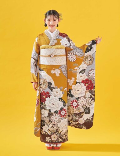 白地に紅・金の花柄があしらわれた振袖姿の女性。白と金の帯締がアクセント。