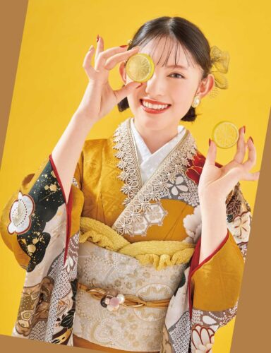 白地に紅・金の花柄があしらわれた振袖姿の女性。白と金の帯締がアクセント。