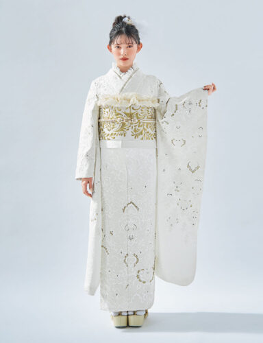白地に金刺繍が施された振袖を着た女性。帯締が華やかさを添える格式高い装い。