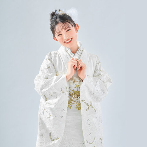 白地に金刺繍が施された振袖を着た女性。帯締が華やかさを添える格式高い装い。