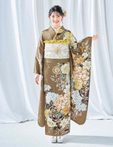 茶色地に花柄が咲く振袖姿の女性。金銀の帯締がアクセント。