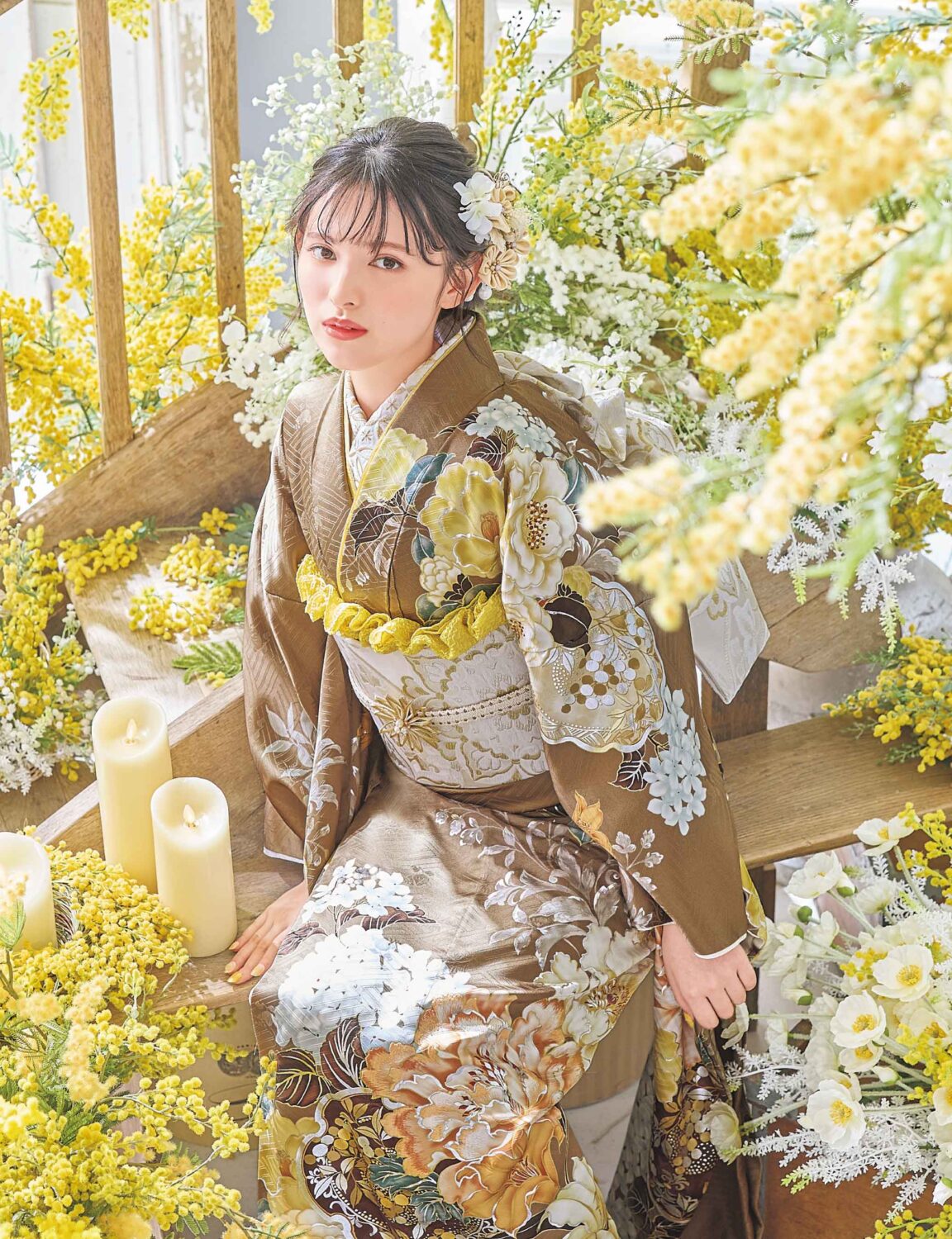 茶色地に花柄が咲く振袖姿の女性。金銀の帯締がアクセント。