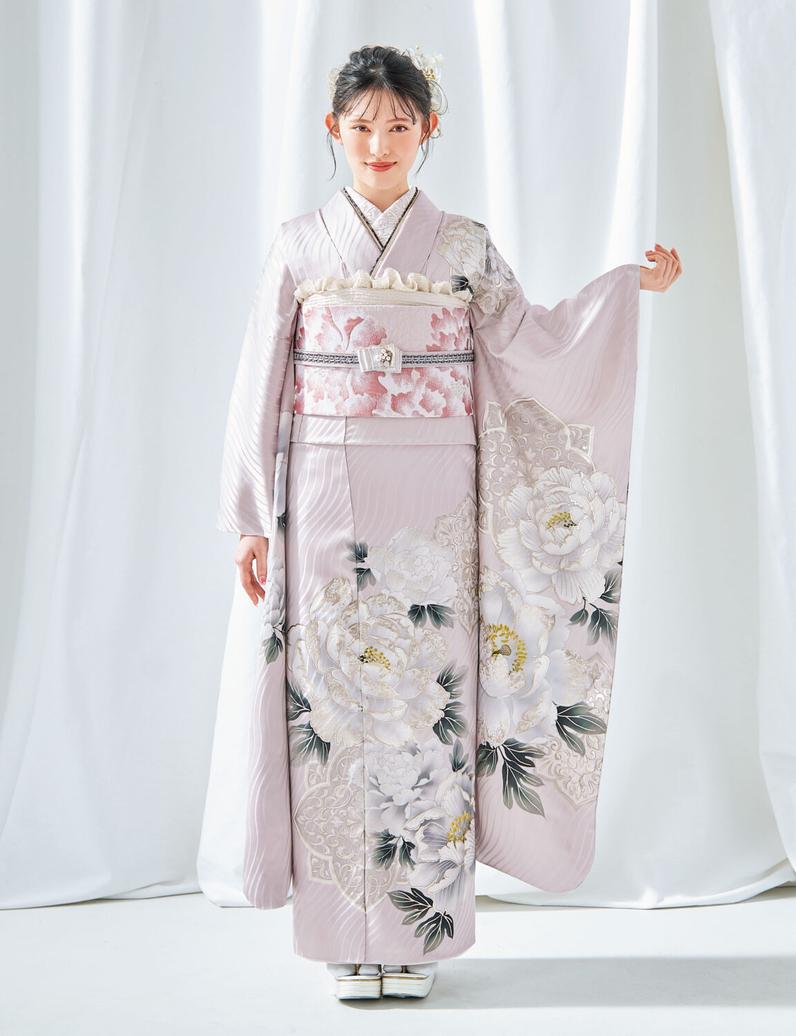 白牡丹の柄が美しい桃色の振袖を着た女性の全身姿