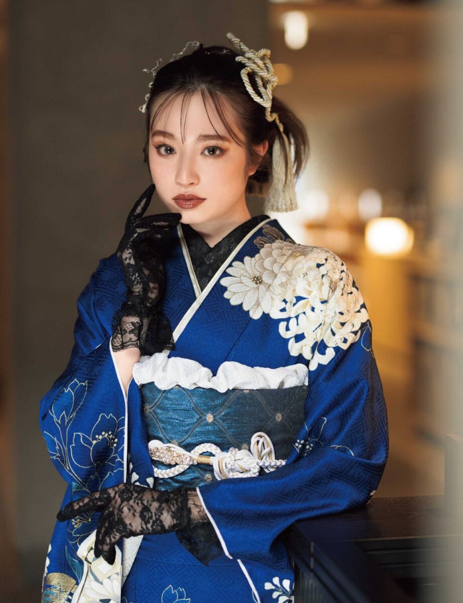 白金の花模様が美しい深藍の振袖を着た女性。気品ある帯締がアクセント。