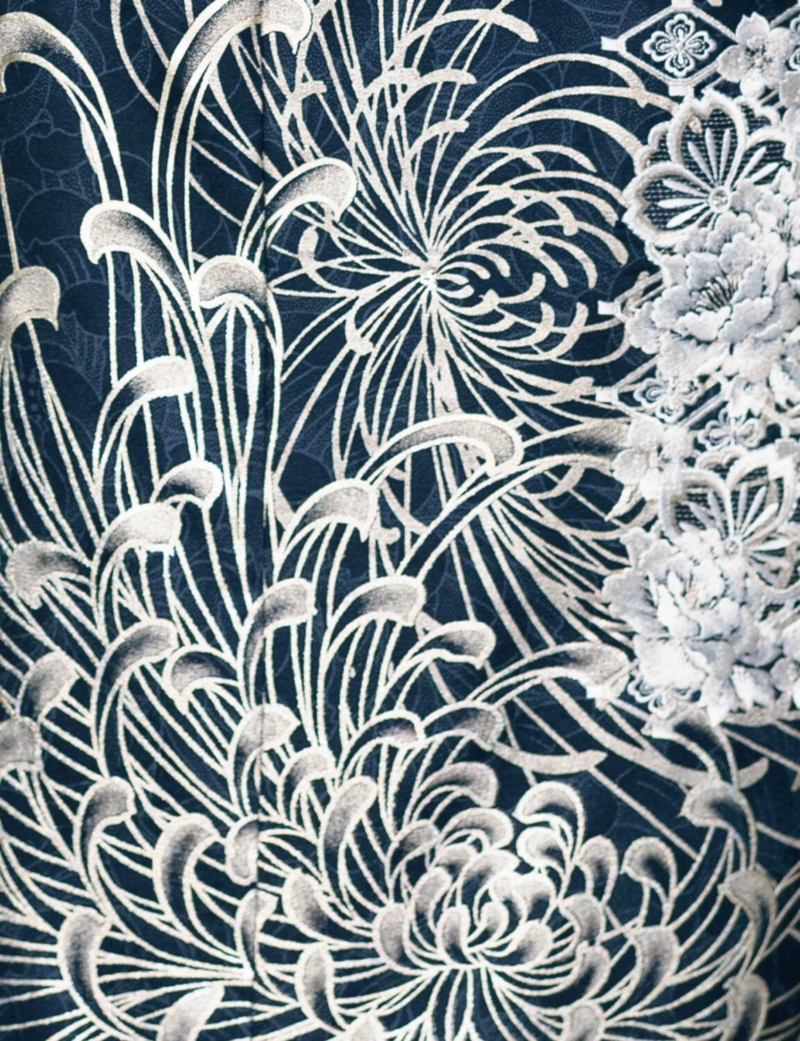 藍地に銀の菊模様が施された振袖姿の女性。帯締とバッグが調和し、優美な印象を与える装い。