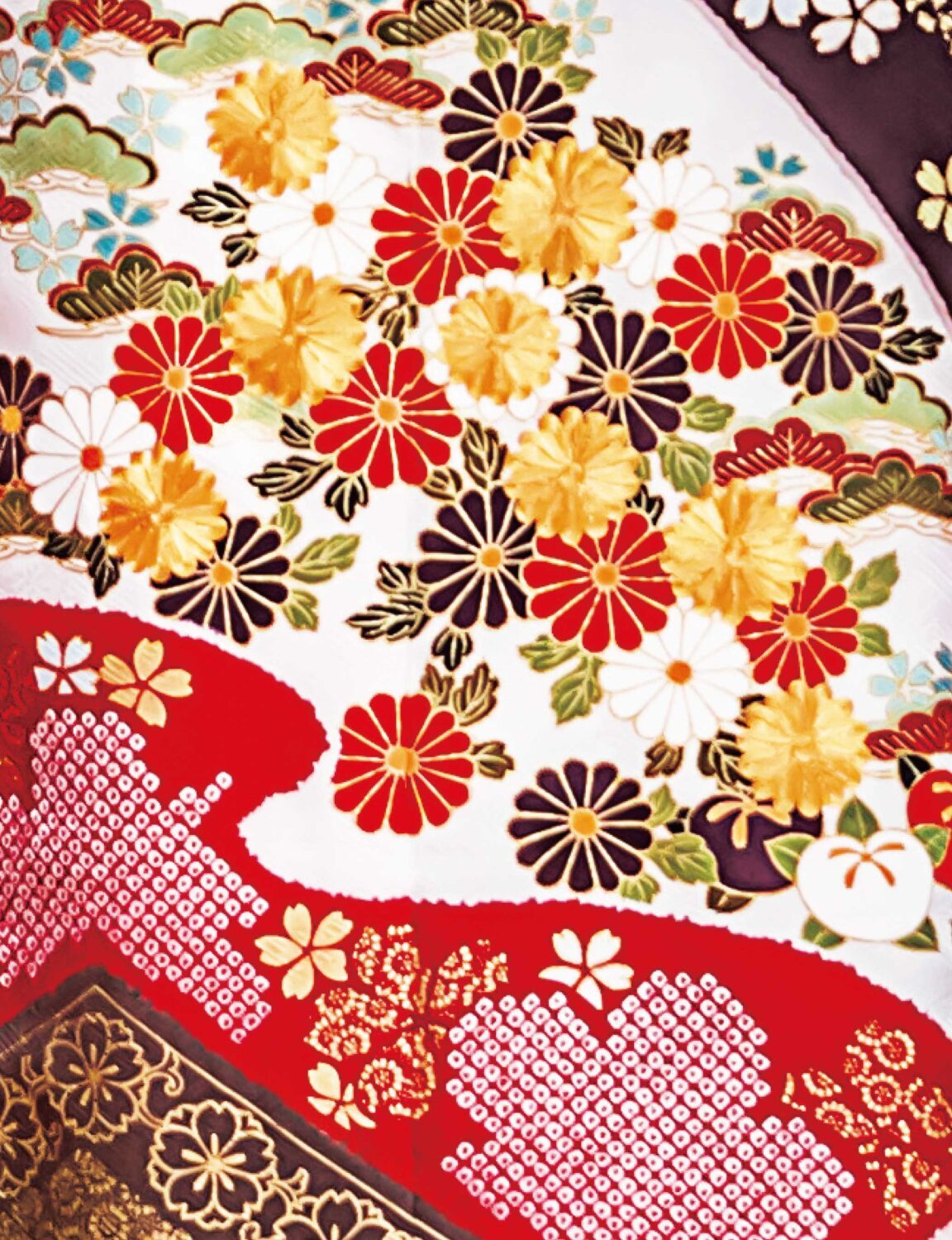 深紅と金彩の振袖を纏った女性が、花と幾何学模様の意匠と帯締の煌めきで華やかに装っている様子