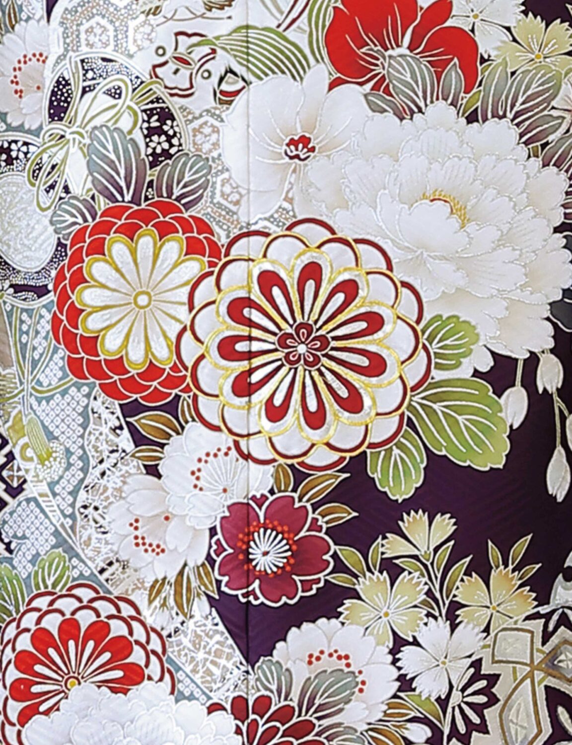 紫地に菊や牡丹が描かれた振袖姿の女性。白地に橙と緑の帯、彩り豊かな帯締が華やかさを添える。
