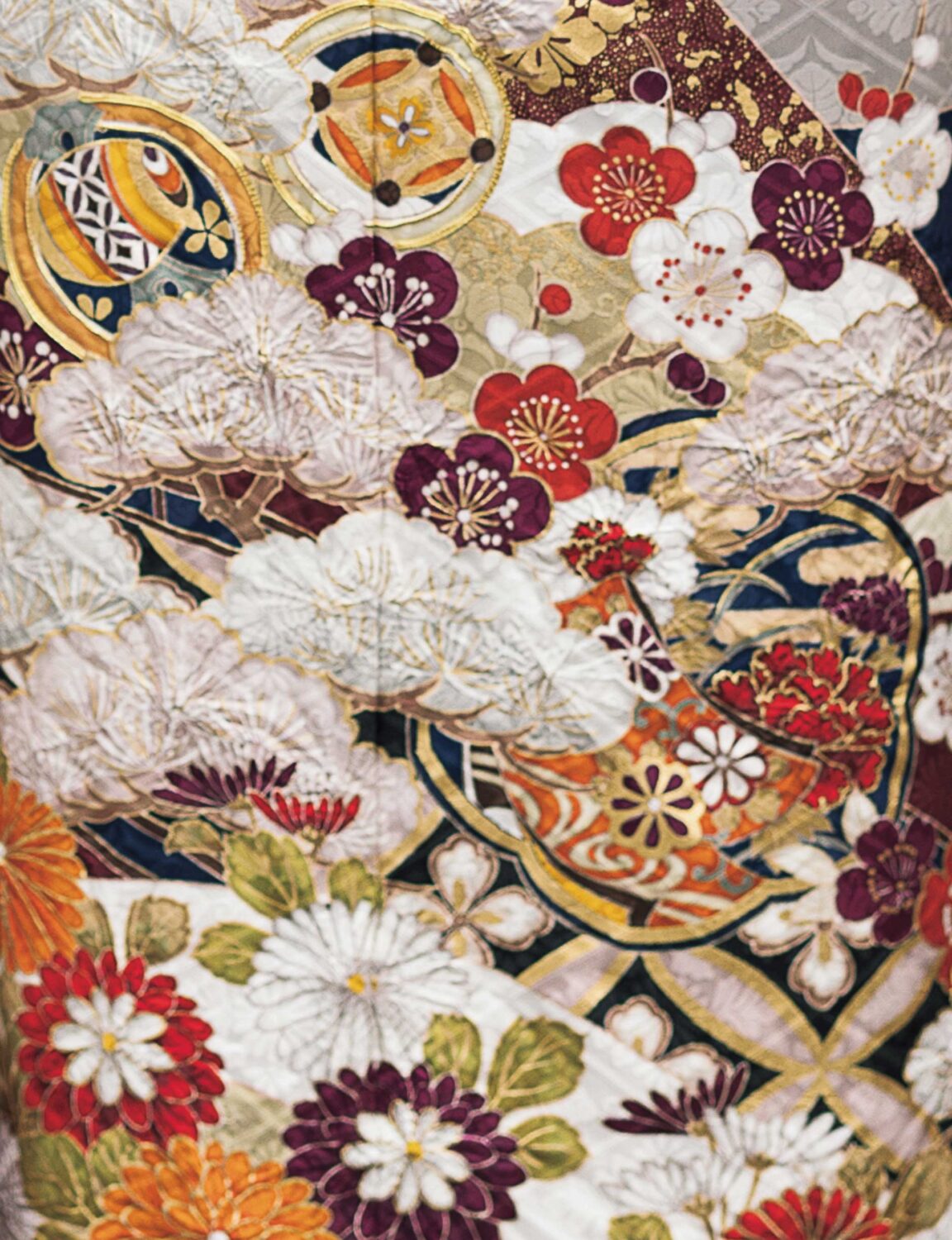 濃紺地に牡丹と菊の花柄が描かれた振袖姿の女性。金の帯締がアクセントになった華やかな装い。