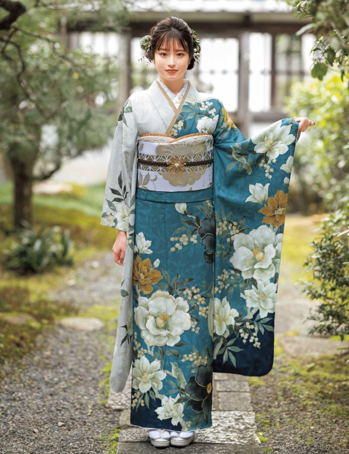 青緑の振袖に白・黄の花柄と金銀の帯締を合わせた華やかで上品な着こなし