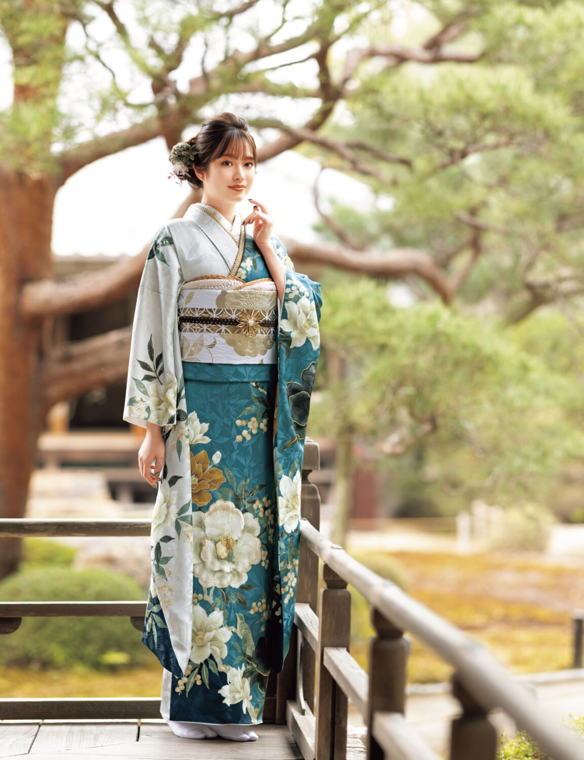 青緑の振袖に白・黄の花柄と金銀の帯締を合わせた華やかで上品な着こなし