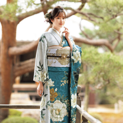 青緑の振袖に白・黄の花柄と金銀の帯締を合わせた華やかで上品な着こなし
