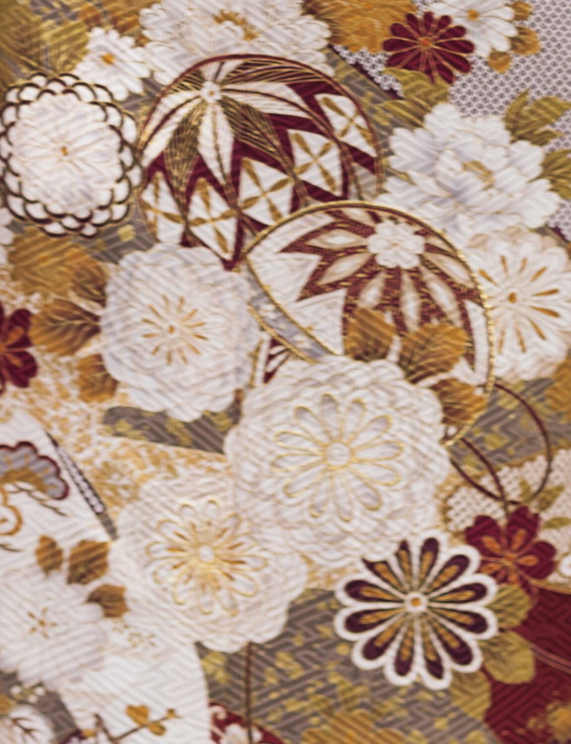 バーガンディに金彩と花柄が施された振袖姿の女性。紫の帯締がアクセント。