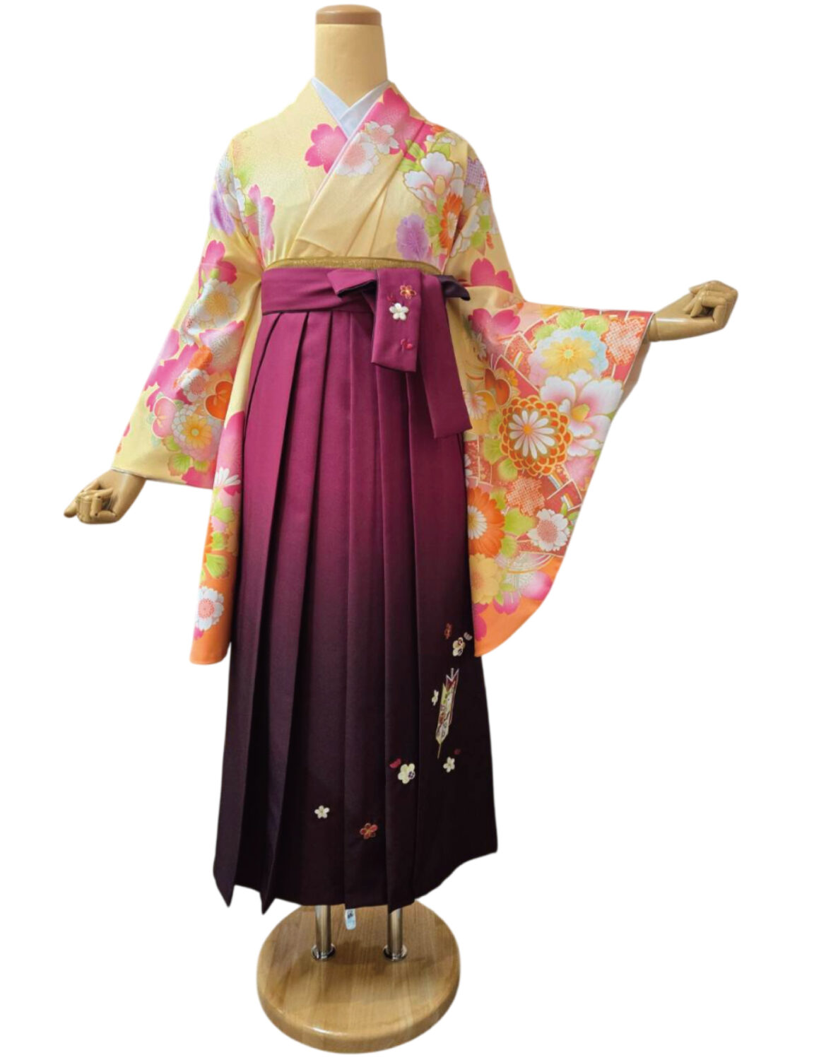 桜と菊の花柄が映えるクリーム地の着物と深紅の袴姿