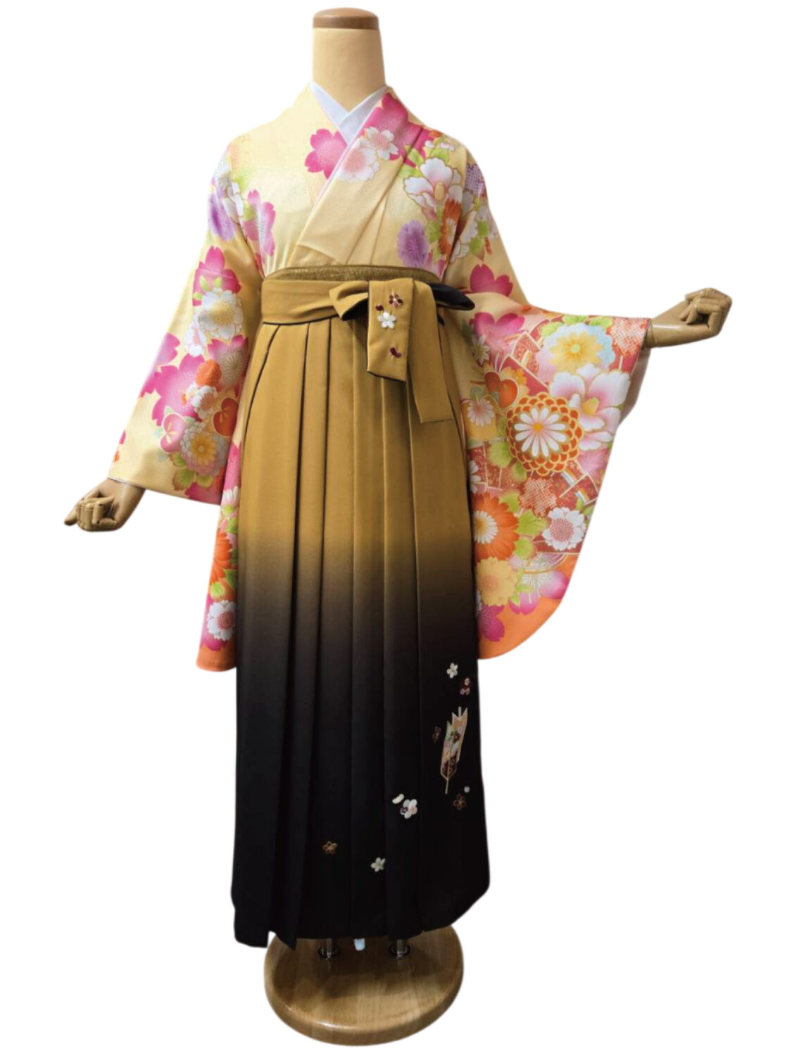 桜と菊の花柄が映えるクリーム地の着物と深紅の袴姿