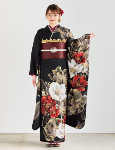 黒地に金・白・赤の花柄をあしらい、深紅の帯と白の帯締を合わせた女性が、重厚で華やかな振袖姿を見せている様子。