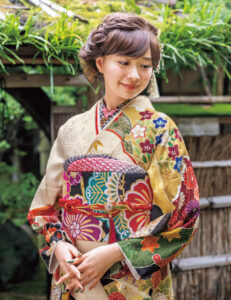 笑顔をやわらかく引き立てる胡粉色に菊づくしの意匠が豪華絢爛。折り重なる雪輪の中には四季の花がいきいきと咲き競います。
