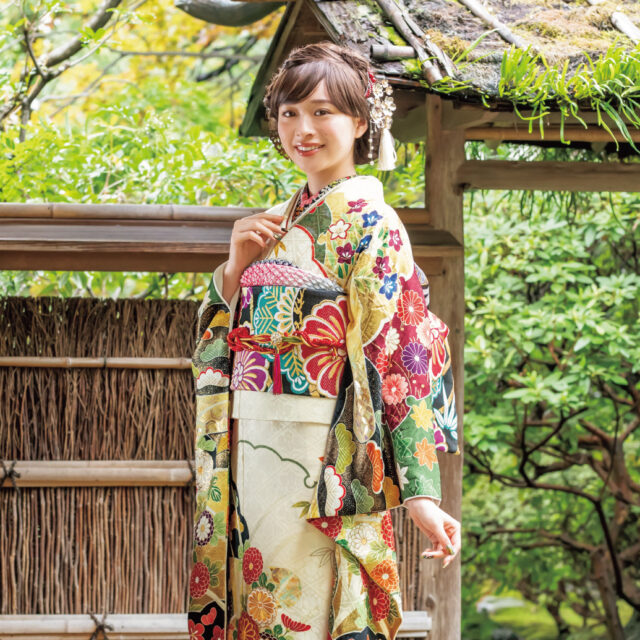 笑顔をやわらかく引き立てる胡粉色に菊づくしの意匠が豪華絢爛。折り重なる雪輪の中には四季の花がいきいきと咲き競います。